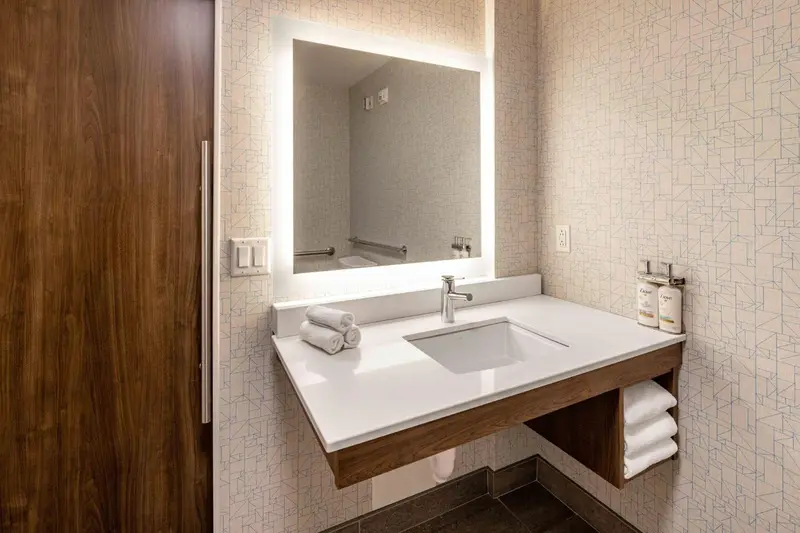 Une salle de bain moderne avec un lavabo et un grand miroir éclairé.