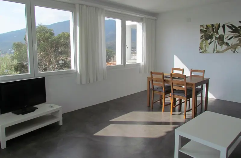 Interieur lumineux avec table a manger et television.