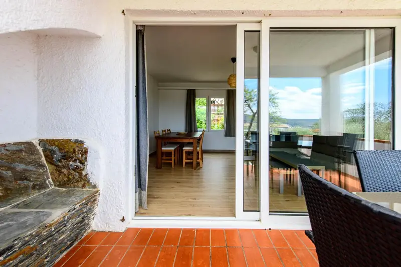 Une terrasse donne sur une piece a vivre lumineuse avec une table a manger.