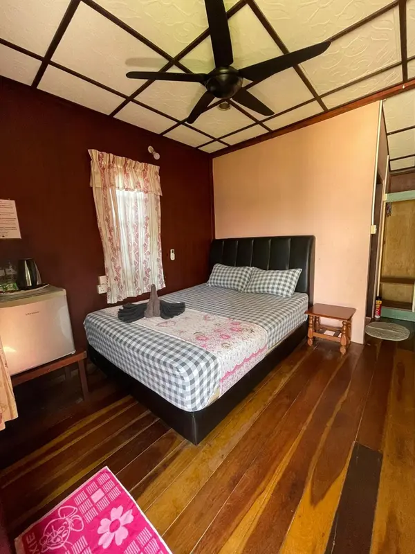 Une chambre lumineuse avec un lit recouvert d'une courtepointe.