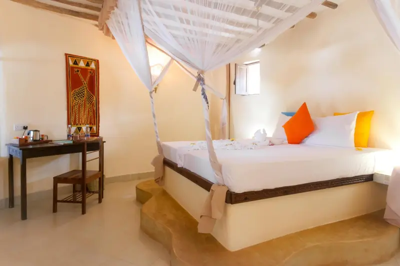 Une chambre lumineuse avec un lit à baldaquin et une décoration colorée.