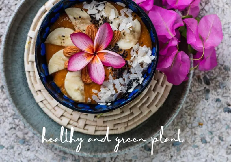 Un bol de smoothie aux fruits décoré d'une fleur et de noix, sur une surface texturée.
