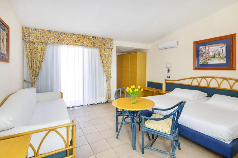 Une chambre lumineuse avec un coin repas et un canapé.