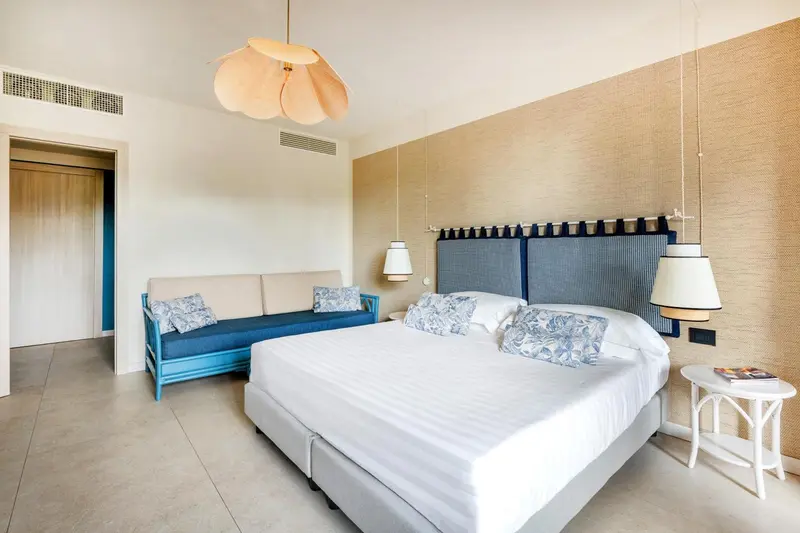 Une chambre lumineuse avec un lit double et un canapé.