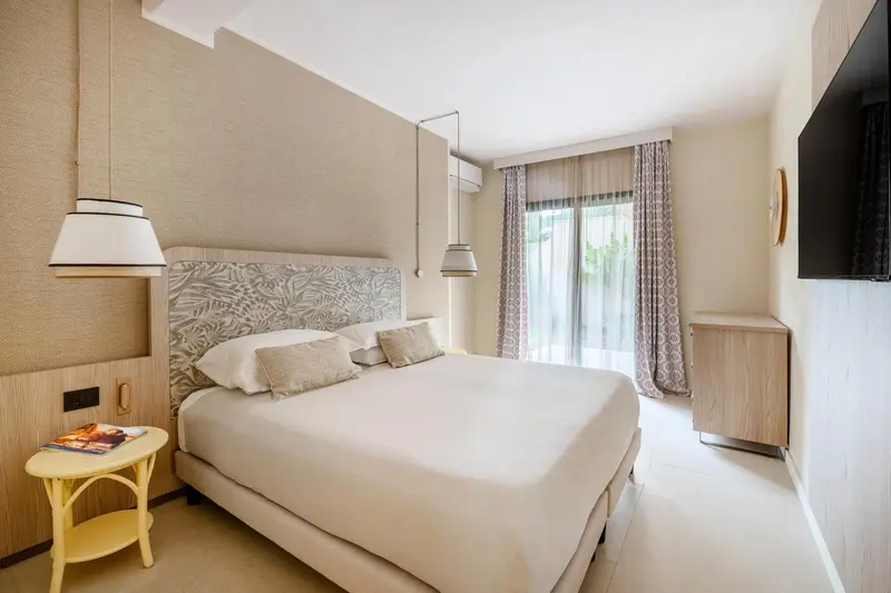 Une chambre lumineuse avec un grand lit et une fenêtre donnant sur l'extérieur.
