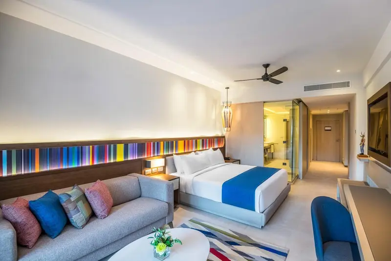 Une chambre lumineuse avec un canapé, un lit et un bureau.
