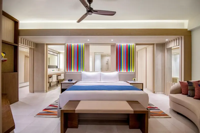 Une chambre lumineuse avec un grand lit et une décoration colorée.