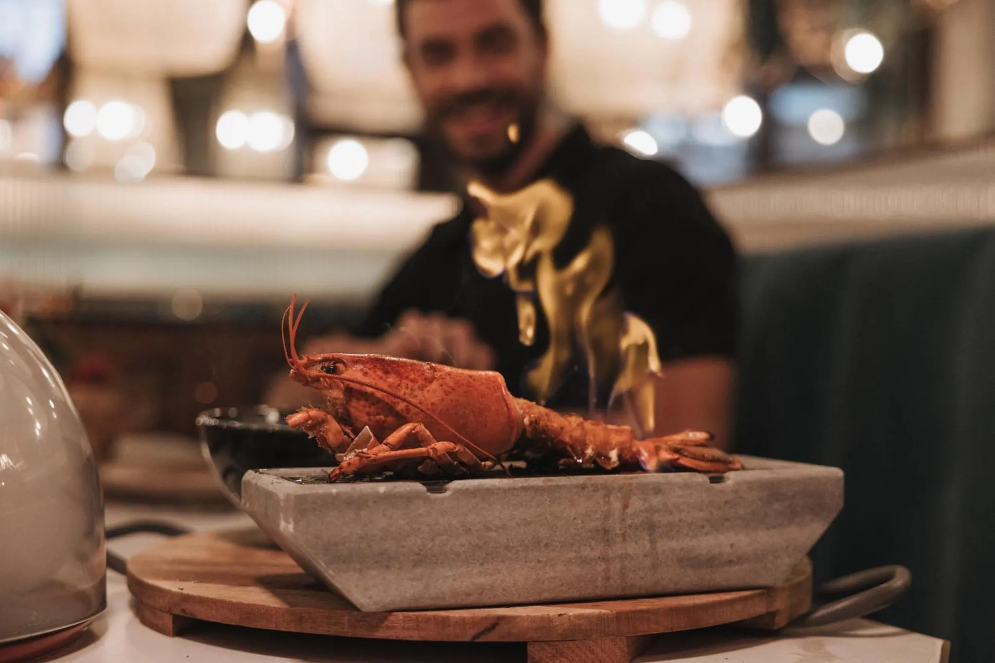 Un plat de homard flambe est présenté sur une table.