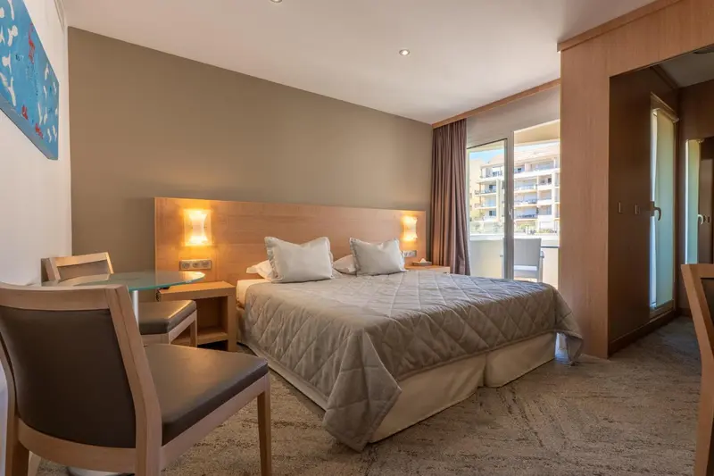 Une chambre lumineuse avec un grand lit et un coin salon.