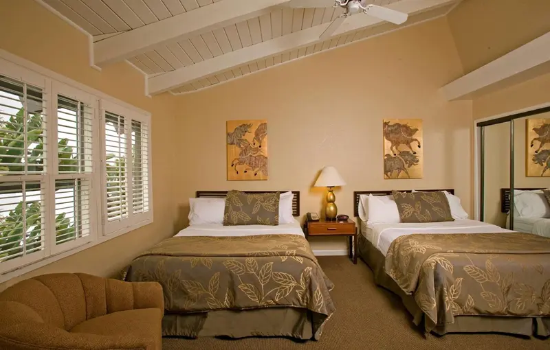 Chambre avec deux lits et décoration murale.