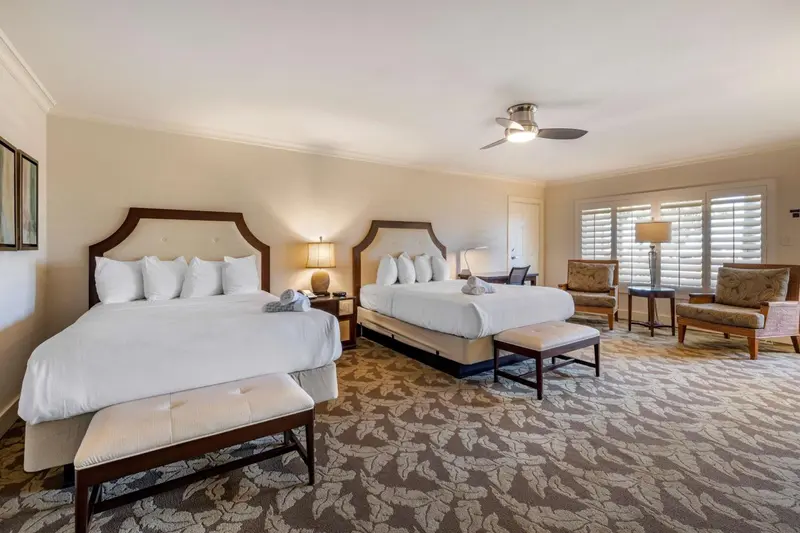 Une chambre lumineuse avec deux lits et un coin salon.