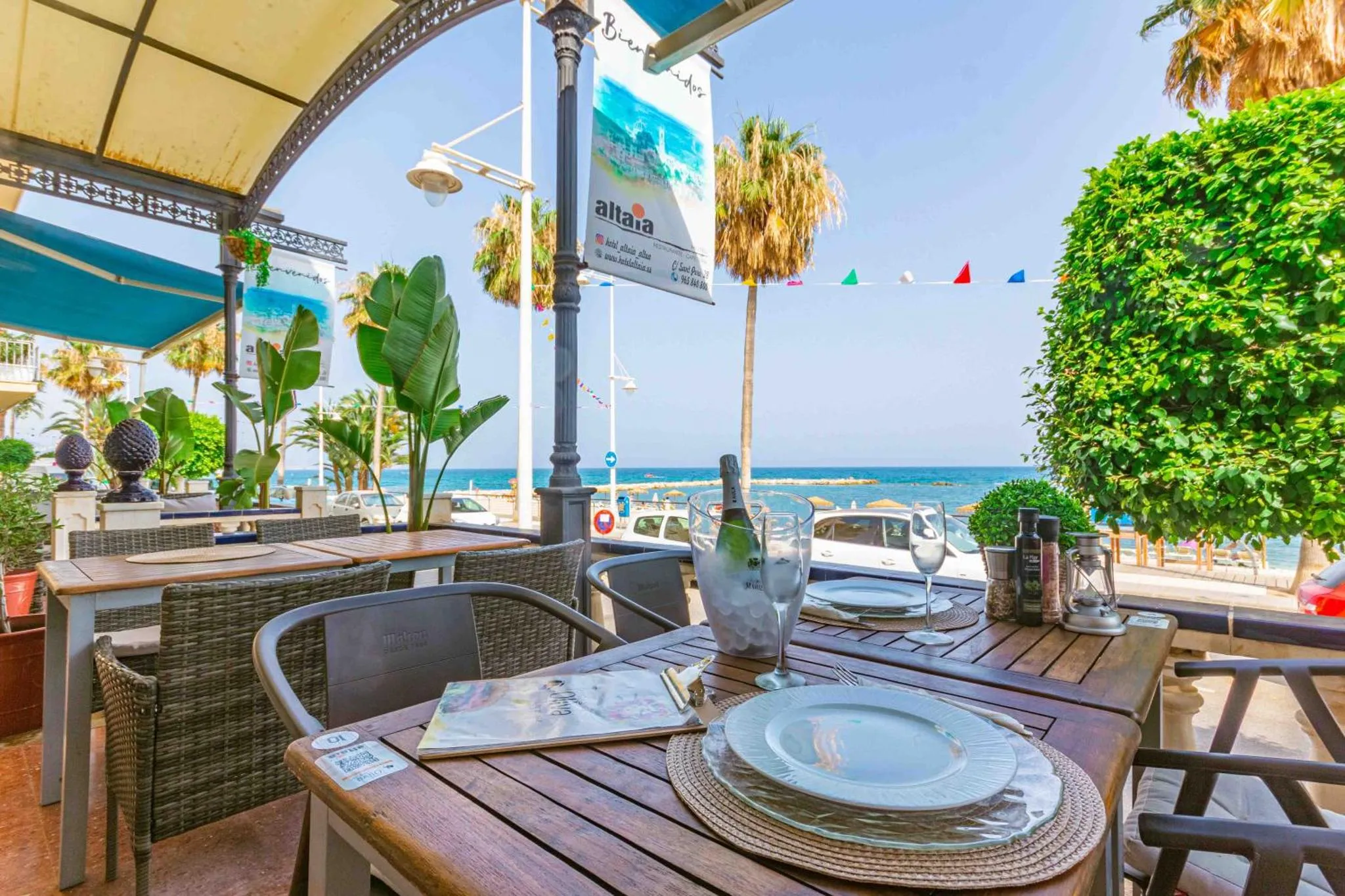 Tables dressées en terrasse avec vue sur la mer.