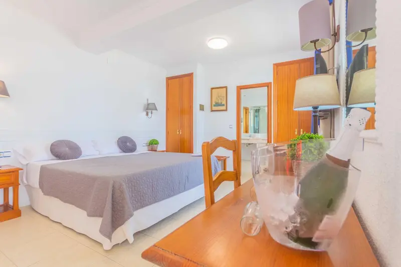Une chambre lumineuse avec un lit et un coin coiffeuse.
