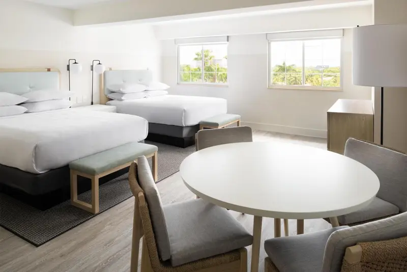 Deux lits simples dans une chambre lumineuse avec un coin repas.