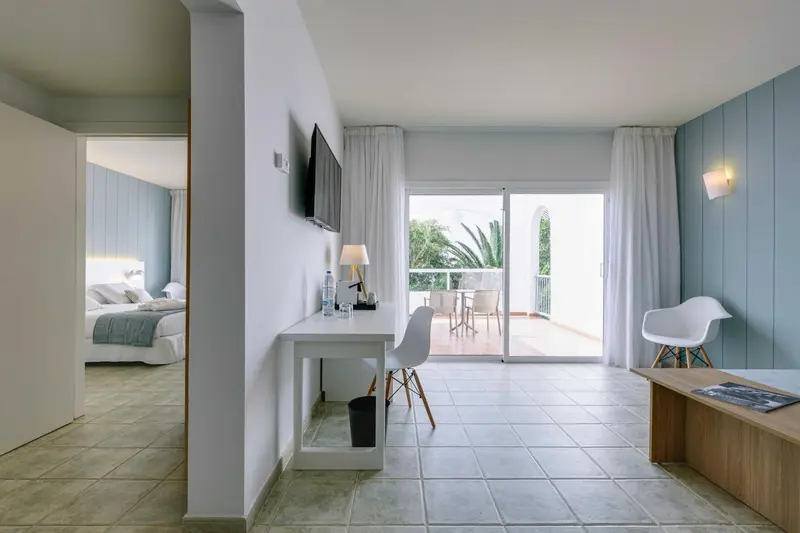 Une chambre lumineuse s'ouvre sur une terrasse avec mobilier.