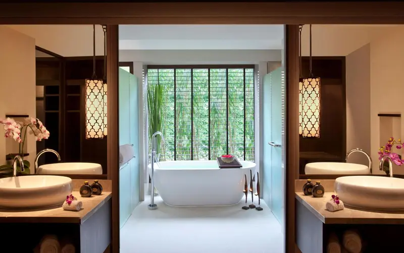 Une salle de bain lumineuse avec baignoire et deux vasques.