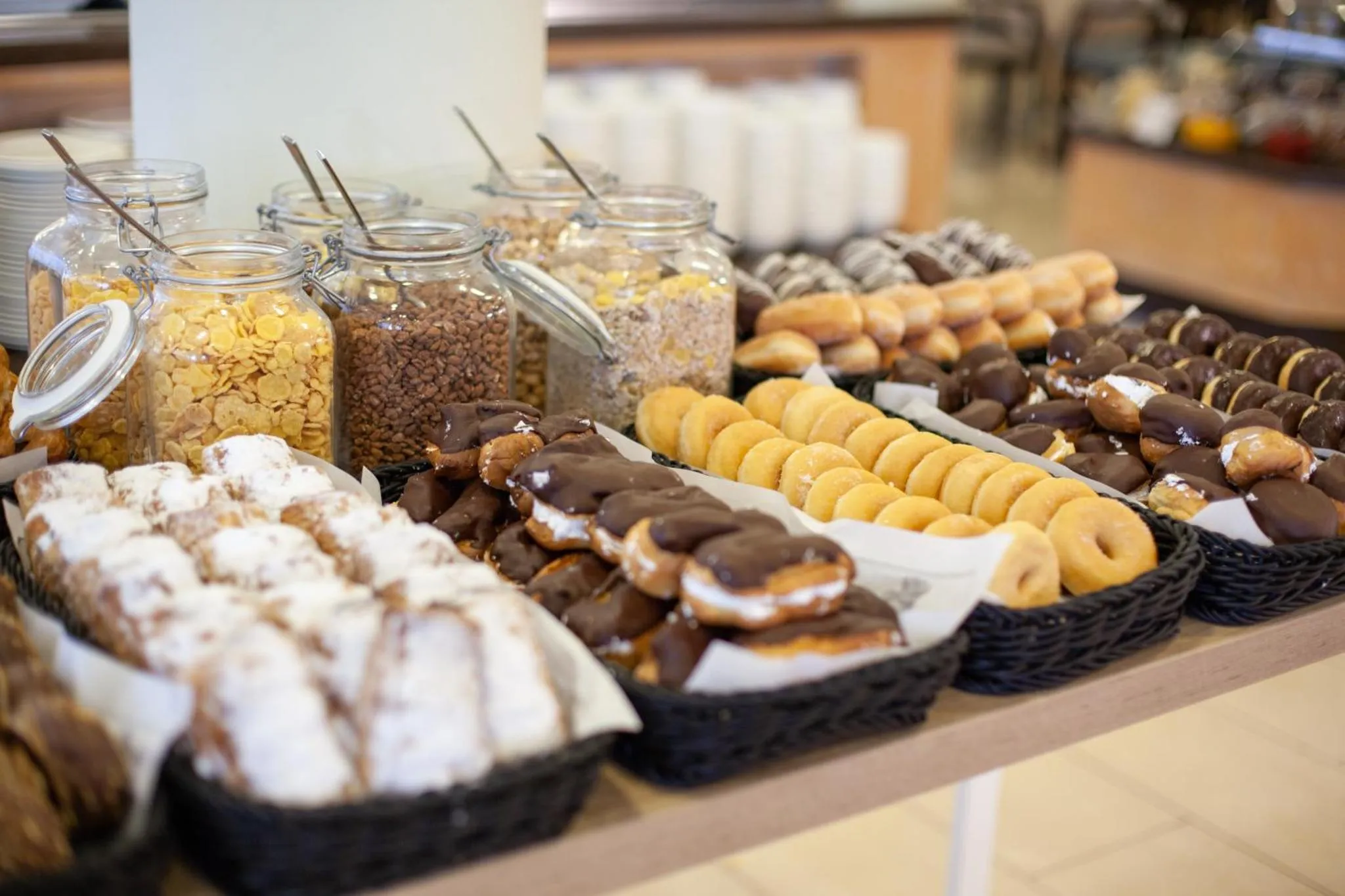 Un buffet propose une variété de pâtisseries et de céréales.