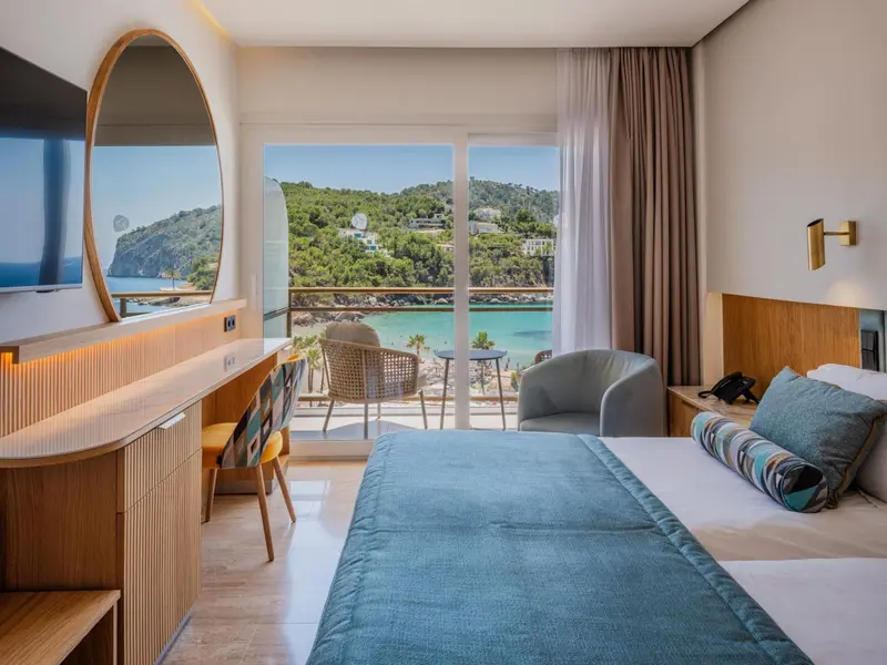 Chambre lumineuse avec vue sur la mer et un coin salon.