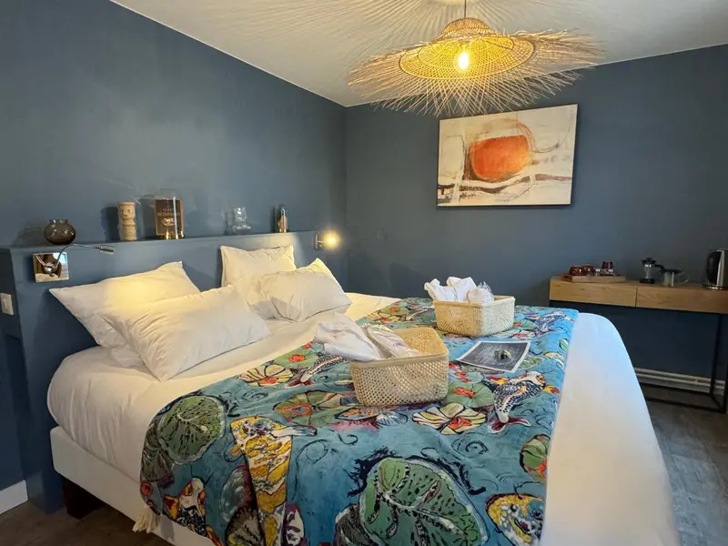 Une chambre avec un grand lit recouvert d'une courtepointe colorée et décorée.