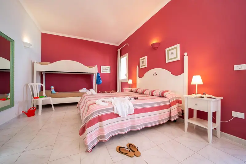 Une chambre lumineuse avec un lit superposé et un lit double.