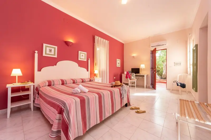 Une chambre lumineuse avec un grand lit et un accès à une terrasse.