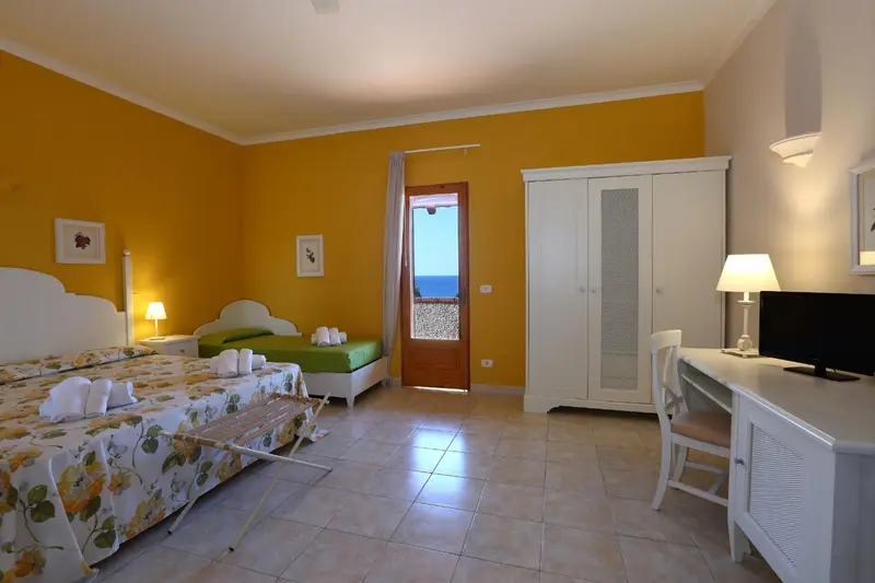 Une chambre lumineuse avec un lit double et un bureau.