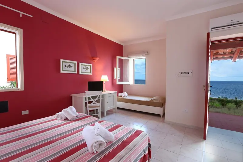 Une chambre lumineuse avec un lit et une vue sur la mer.