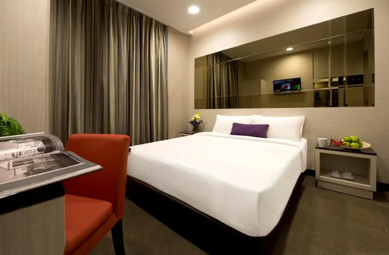 Une chambre d'hotel avec un lit et une table de chevet.