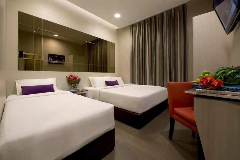 Chambre d'hôtel avec deux lits et une décoration florale.