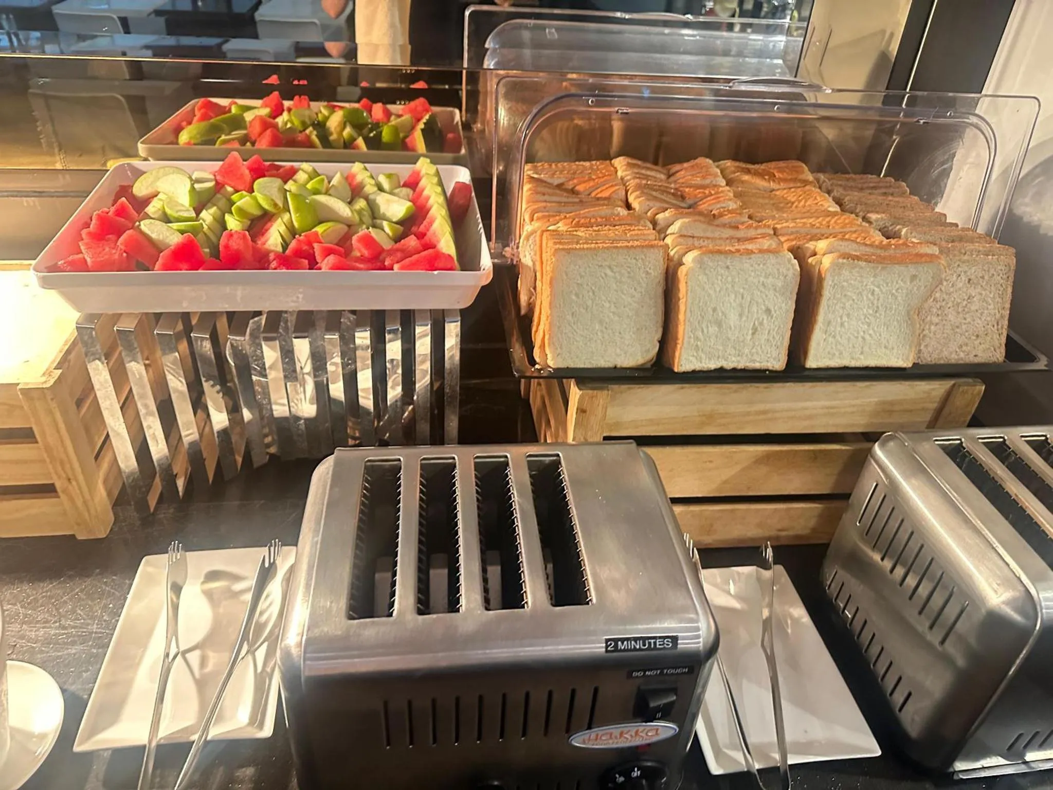 Présentation de fruits frais et de pain grillé sur un buffet.