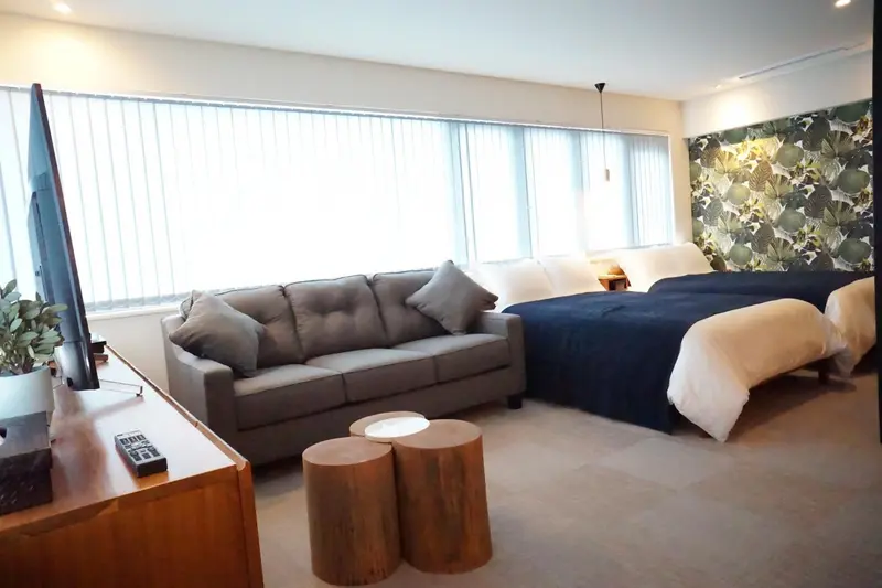 Espace de vie intérieur avec canapé, télévision et lit.