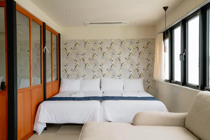 Une chambre lumineuse avec un grand lit et un coin salon.