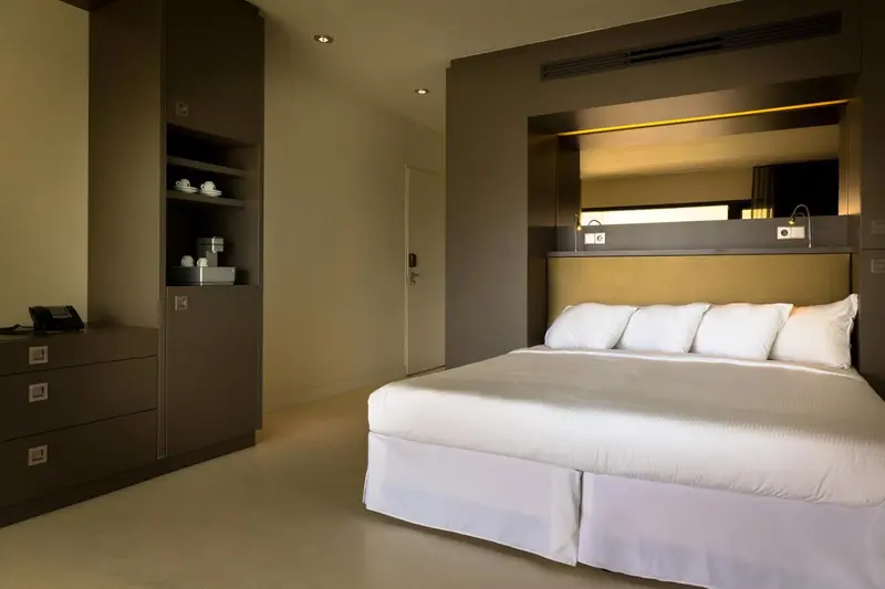 Une chambre moderne avec un grand lit et des meubles en bois.