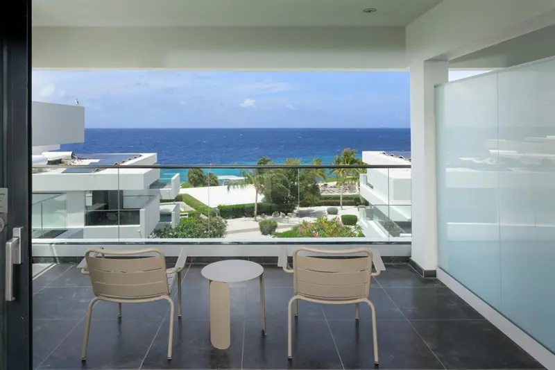 Terrasse avec mobilier d'extérieur donnant sur une vue mer et un paysage urbain.