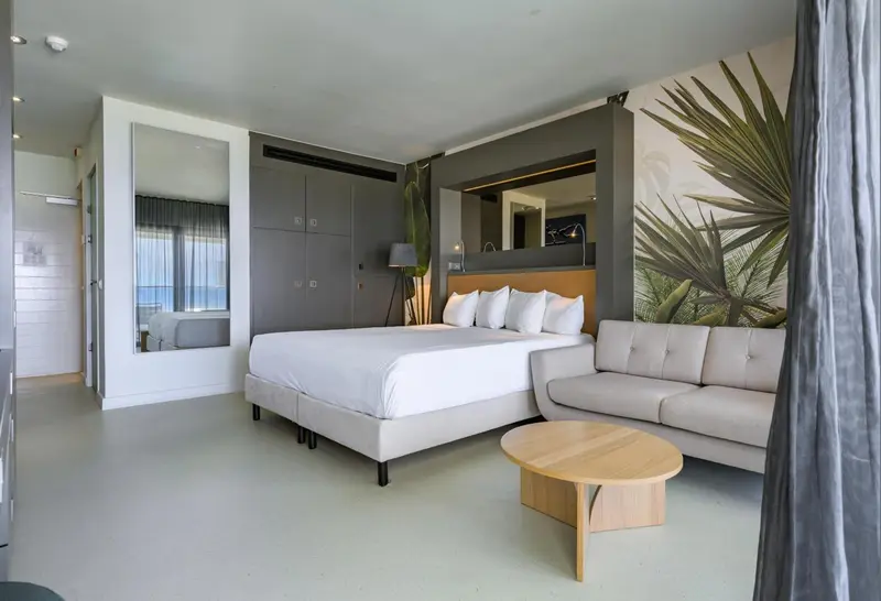 Une chambre spacieuse avec un grand lit et un coin salon.