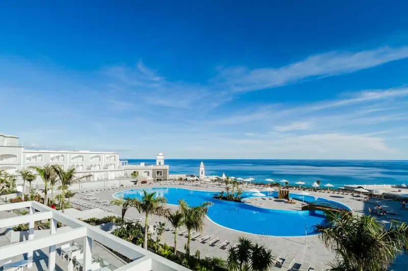 Vue aérienne d'un complexe hôtelier avec piscine et accès à la mer.