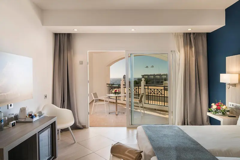 Chambre lumineuse avec un accès direct sur une terrasse offrant une vue sur la mer.