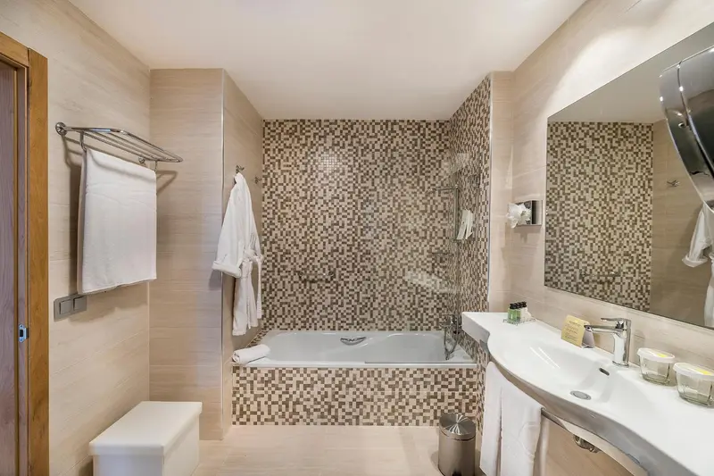 Une salle de bain lumineuse avec baignoire et lavabo.