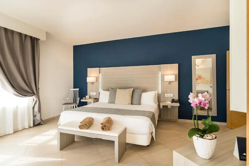 Une chambre lumineuse avec un grand lit et une décoration sobre.