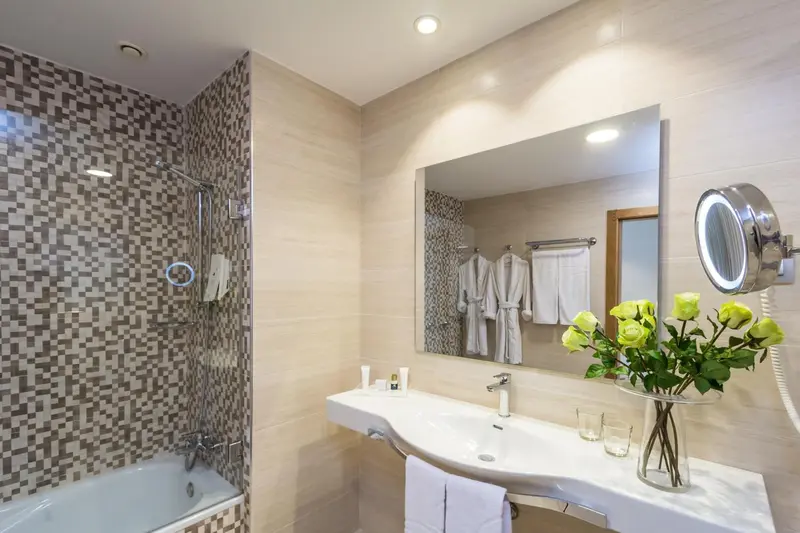 Une salle de bain lumineuse avec une baignoire et un lavabo décoré de fleurs.