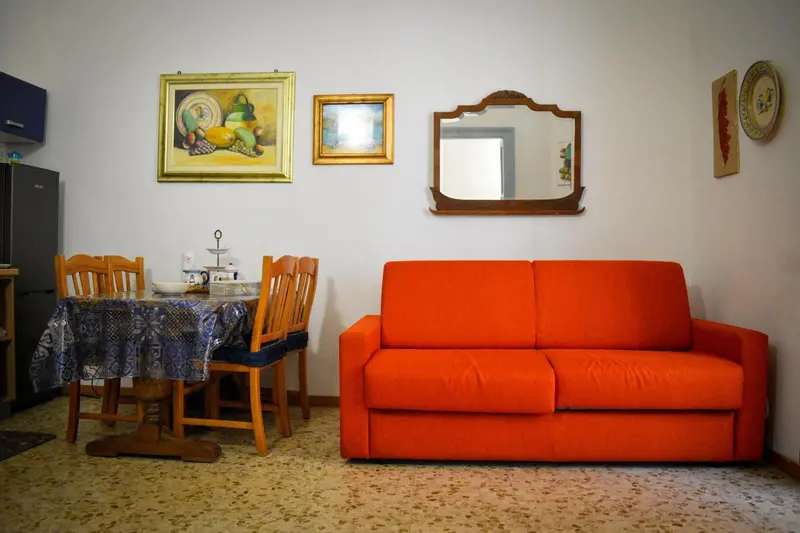 Une pièce de vie avec un canapé orange et une table à manger.