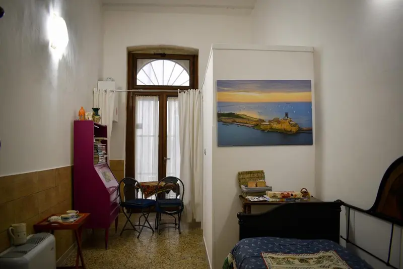 Une pièce lumineuse avec un lit, une table et des chaises près d'une fenêtre.