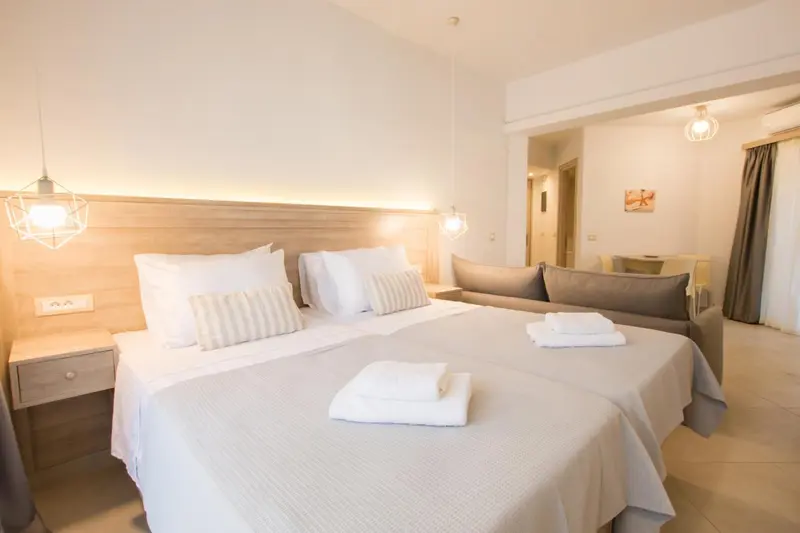 Une chambre lumineuse avec un grand lit et un canapé.