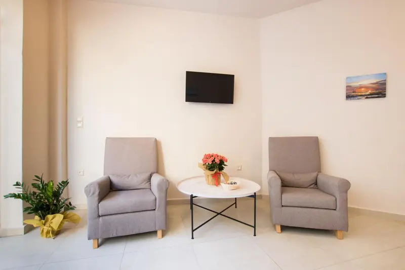 Un salon lumineux avec deux fauteuils confortables et une table basse décorée de fleurs.