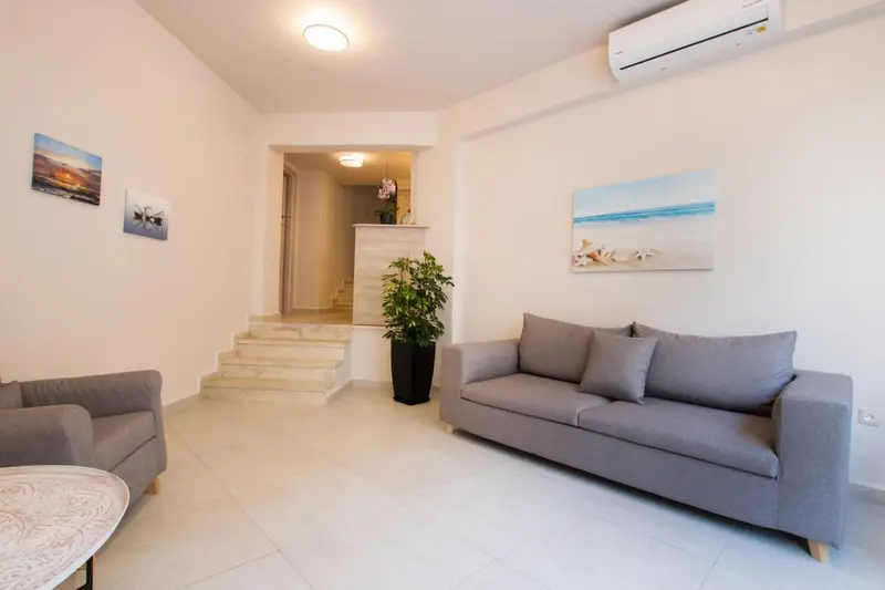 Espace de détente intérieur avec canapés et tableaux décoratifs.