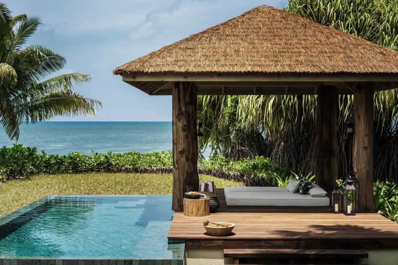 Un espace de détente extérieur avec une petite piscine et un lit de repos.