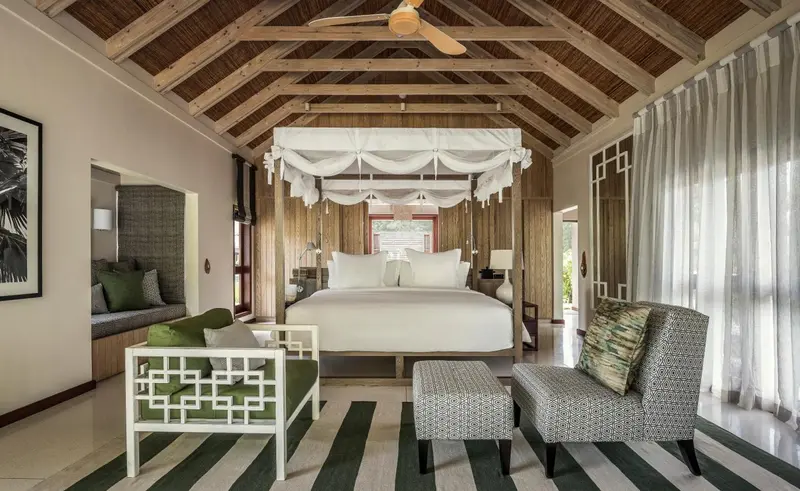Une chambre lumineuse avec un grand lit à baldaquin et un mobilier en bois clair.