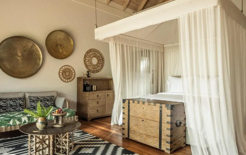 Une chambre lumineuse avec un lit à baldaquin et une décoration murale en bois.