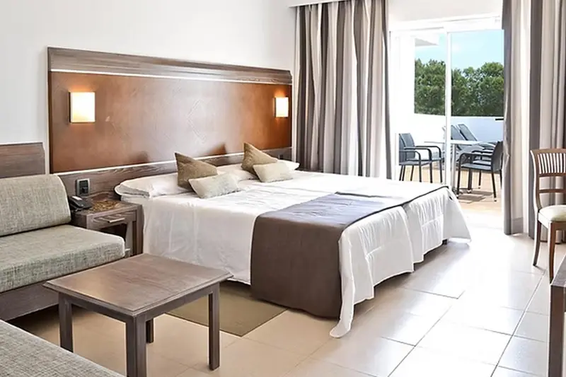 Une chambre lumineuse avec un grand lit et un accès à une terrasse.