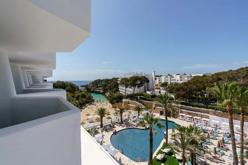 Vue d'une piscine et d'une plage depuis un balcon.
